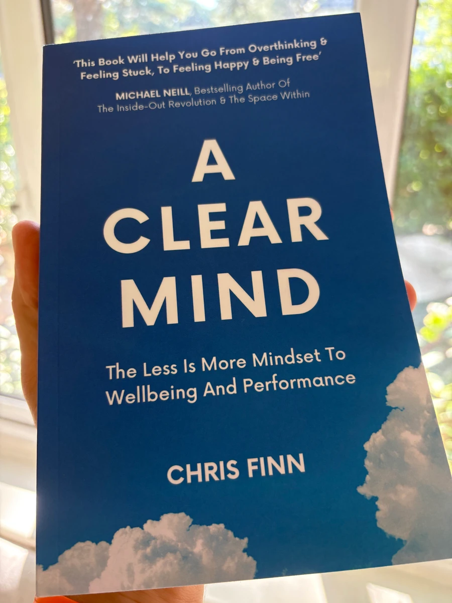 A copy of A Clear Mind held in natural light beside a window
